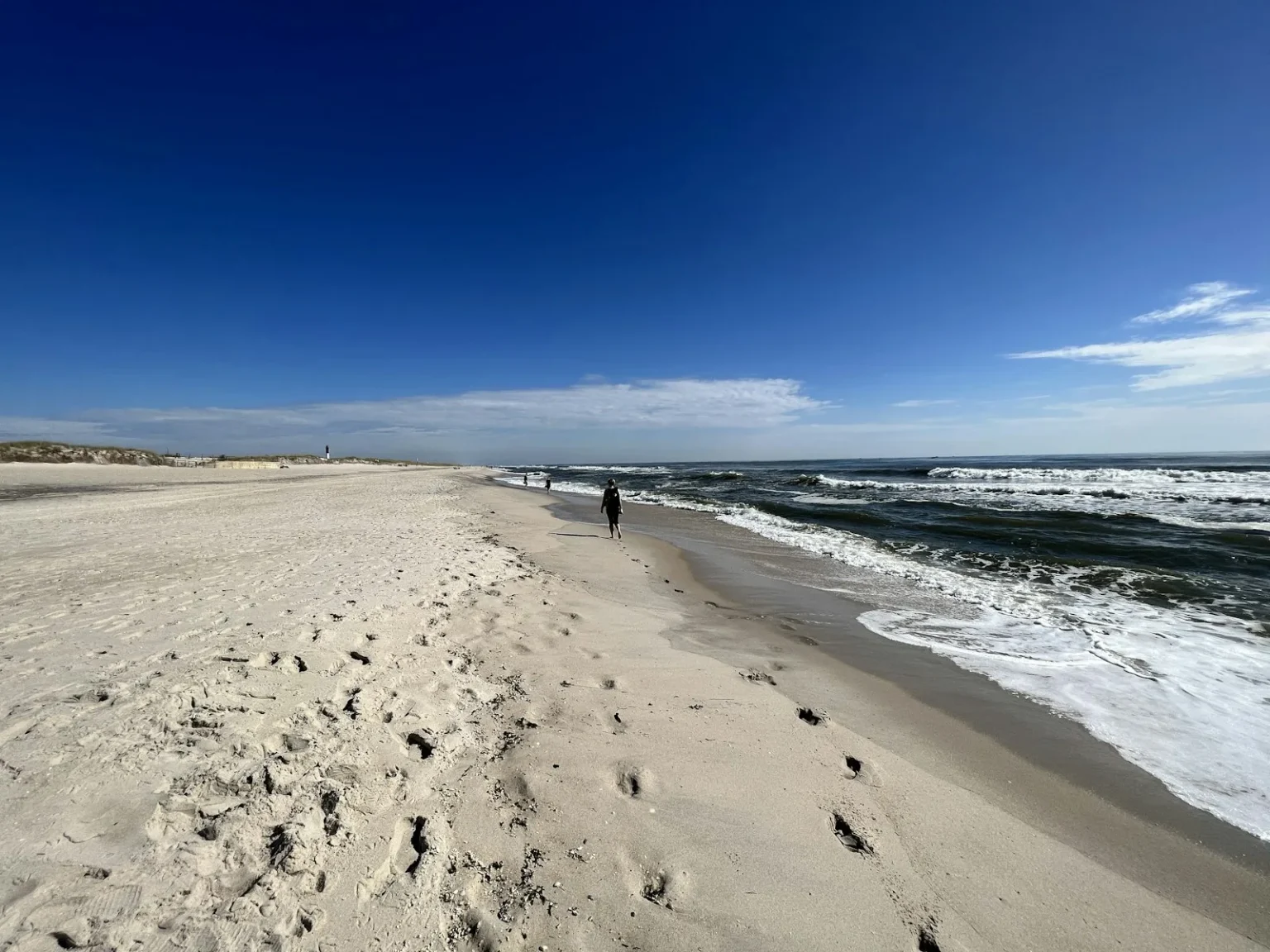 Ocean Beach Fire Island Travel Guide, Fun Things to Do - a person walking on a beach
